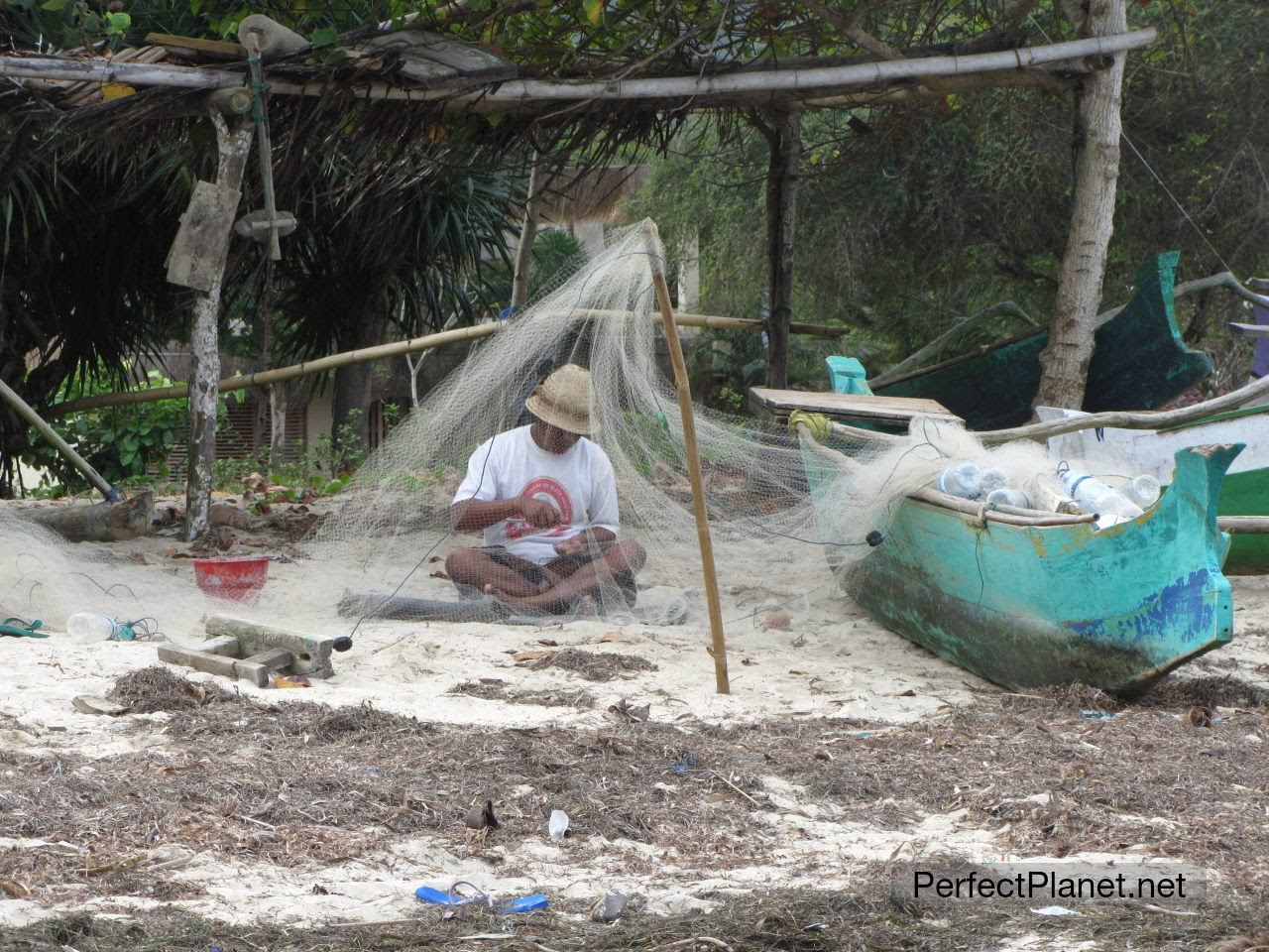 Pescador reparando la red